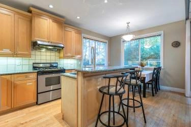 Open kitchen with three side window and eating area lead to sundeck in the yard.