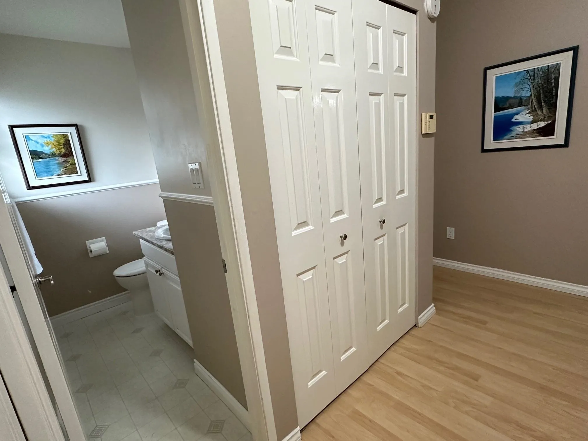 Laminate flooring runs from the entrance into the family room. There's a large coat closet (pictured) plus a second closet where the hot water tank hides. This second closet uses the space under the stairs!